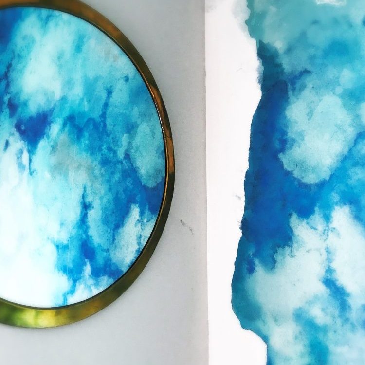 eine Wolkentapete, die sich in einem runden Spielg spiegelt